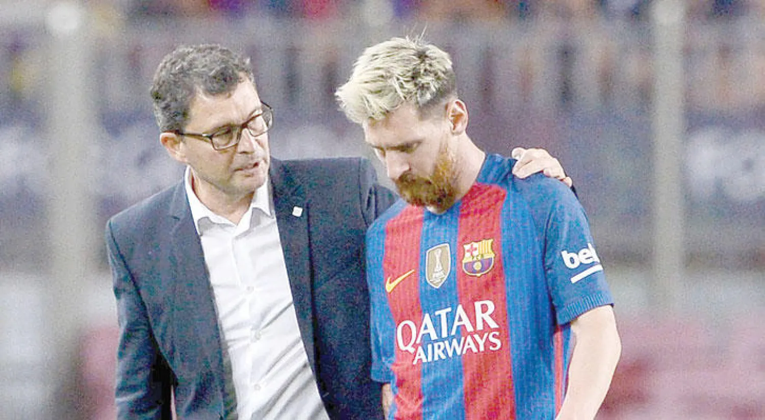 ميسي يخرج من الملعب بصحبة طبيب برشلونة (أ.ف.ب)