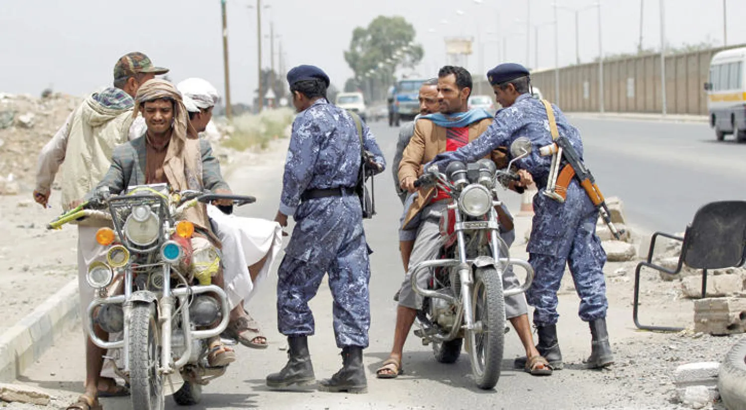 عنصران أمنيان من الأجهزة التابعة للانقلاب تفتش المارة في صنعاء (أ.ف.ب)