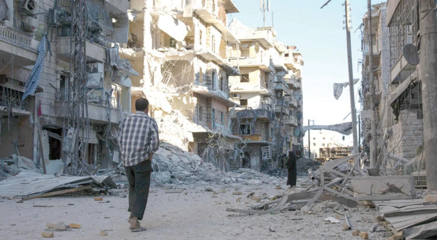 سوري يمر أمام آثار الدمار الذي لحق بأحد أحياء حلب بعد عرضه لقصف جوي (أ.ف.ب)