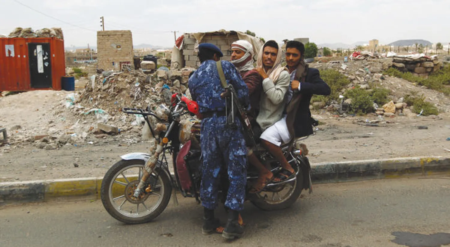 عسكري موال للانقلابيين يوقف يمنيين على متن دراجة نارية في إحدى نقاط التفتيش في العاصمة صنعاء (أ.ف.ب)