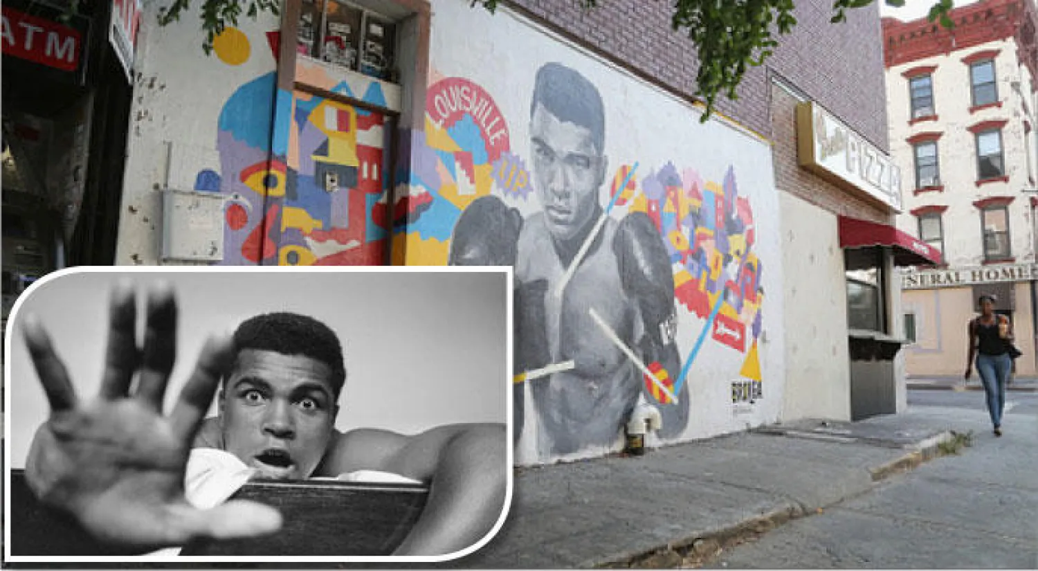 ملصق دعائي للملاكم الأشهر في شوارع نيويورك أغسطس الماضي (غيتي) - لقطة لمحمد علي في غرفة الفندق بلندن عام 1963 وهو يرفع يده مشيرًا إلى لقائه المرتقب مع خصمه هنري كوبر حيث يقرر مسبقًا فوزه بالقاضية في الجولة الخامسة (غيتي)