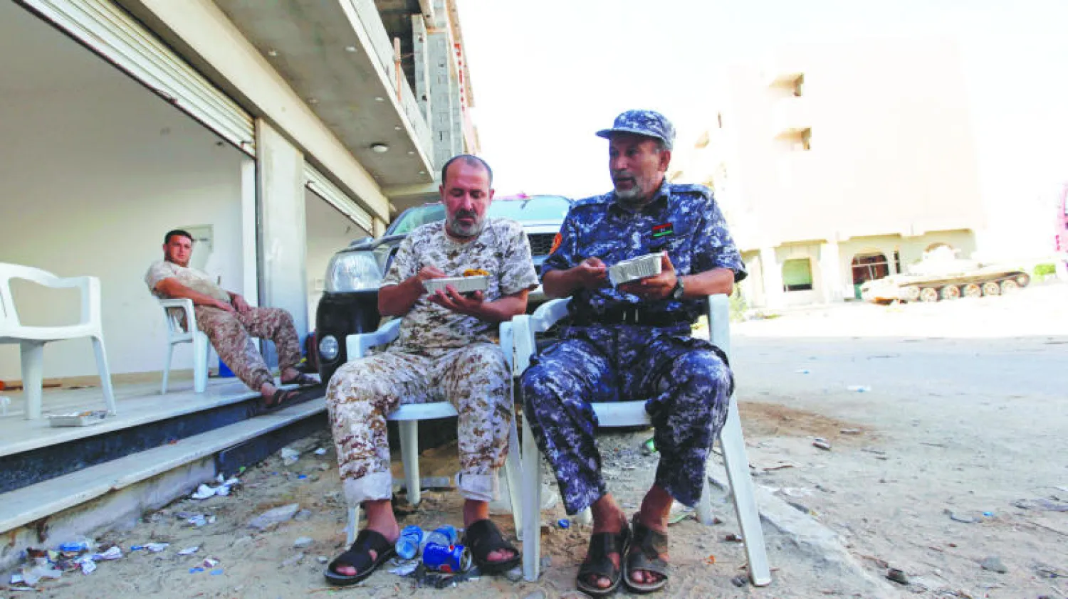 مقاتلان من الجيش في استراحة بعد معارك دامية مع أتباع داعش في سرت (رويترز)