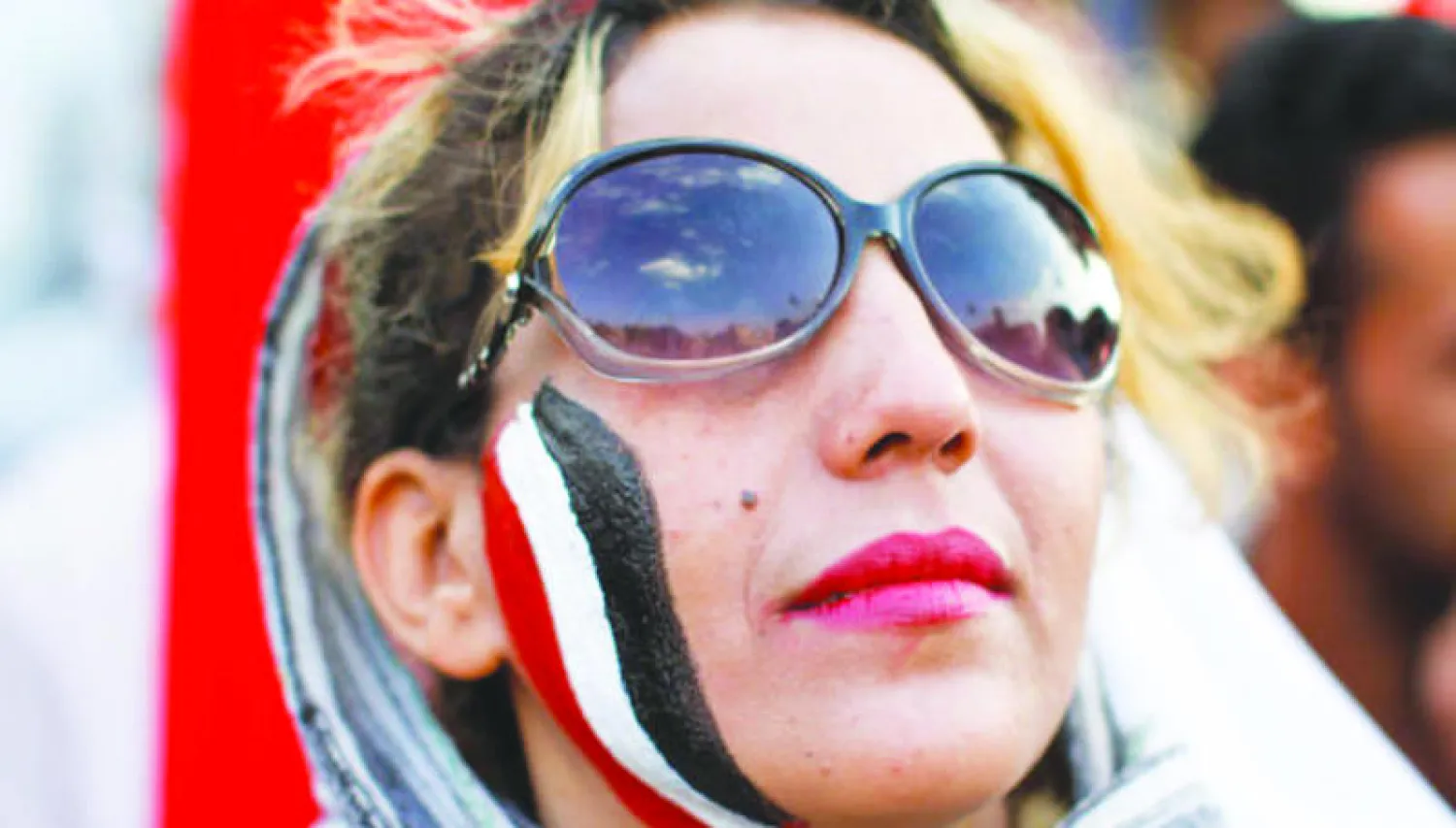 يمنية صبغت خدها بألوان راية بلادها خلال مشاركتها في إحياء ذكرى 26 سبتمبر أمس (رويترز)