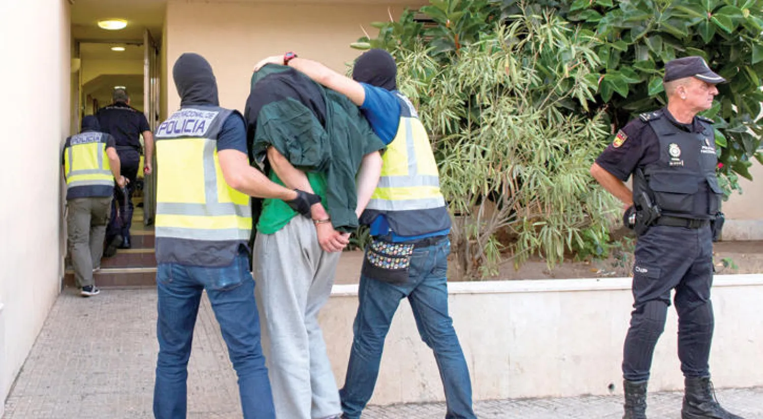 الشرطة الإسبانية تقود معتقلا إلى مركز الشرطة في مليلية أمس (رويترز)