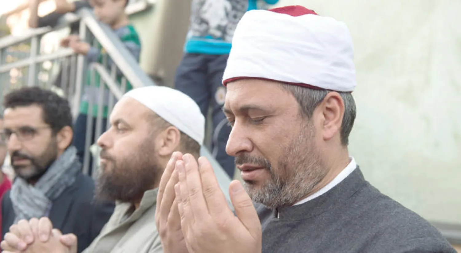 إمام مسجد مروى بدريسدن ومواطنون ألمان في دقيقة صمت أمام مسجد الفاتح أول من أمس (إ.ب.أ)