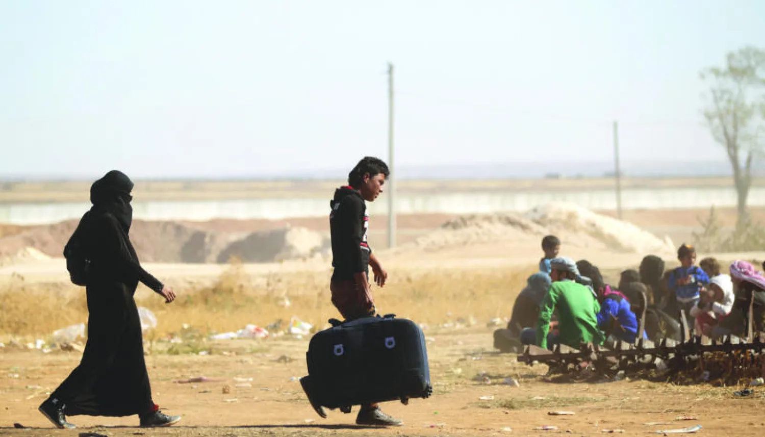 مدنيون فروا من تنظيم داعش شمال سوريا تجمعوا عند نقطة تفتيش للفصائل المعارضة في بلدة الراعي بريف حلب الأربعاء الماضي (رويترز)