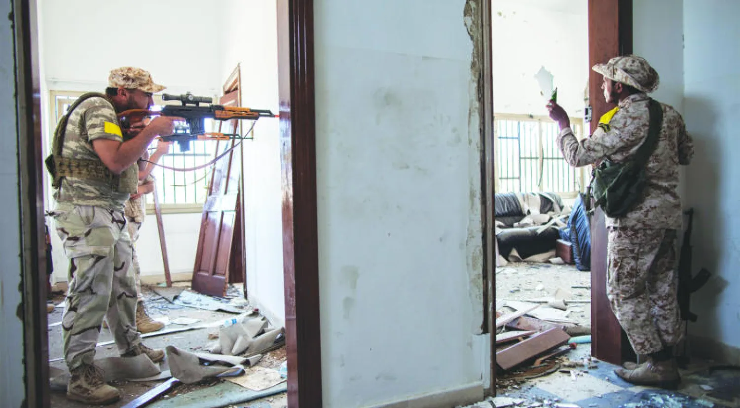 مقاتل موال للحكومة الليبية يوجه بندقيته صوب تجمع لأتباع «داعش» خلال مواجهات في مدينة سرت (أ.ف.ب)