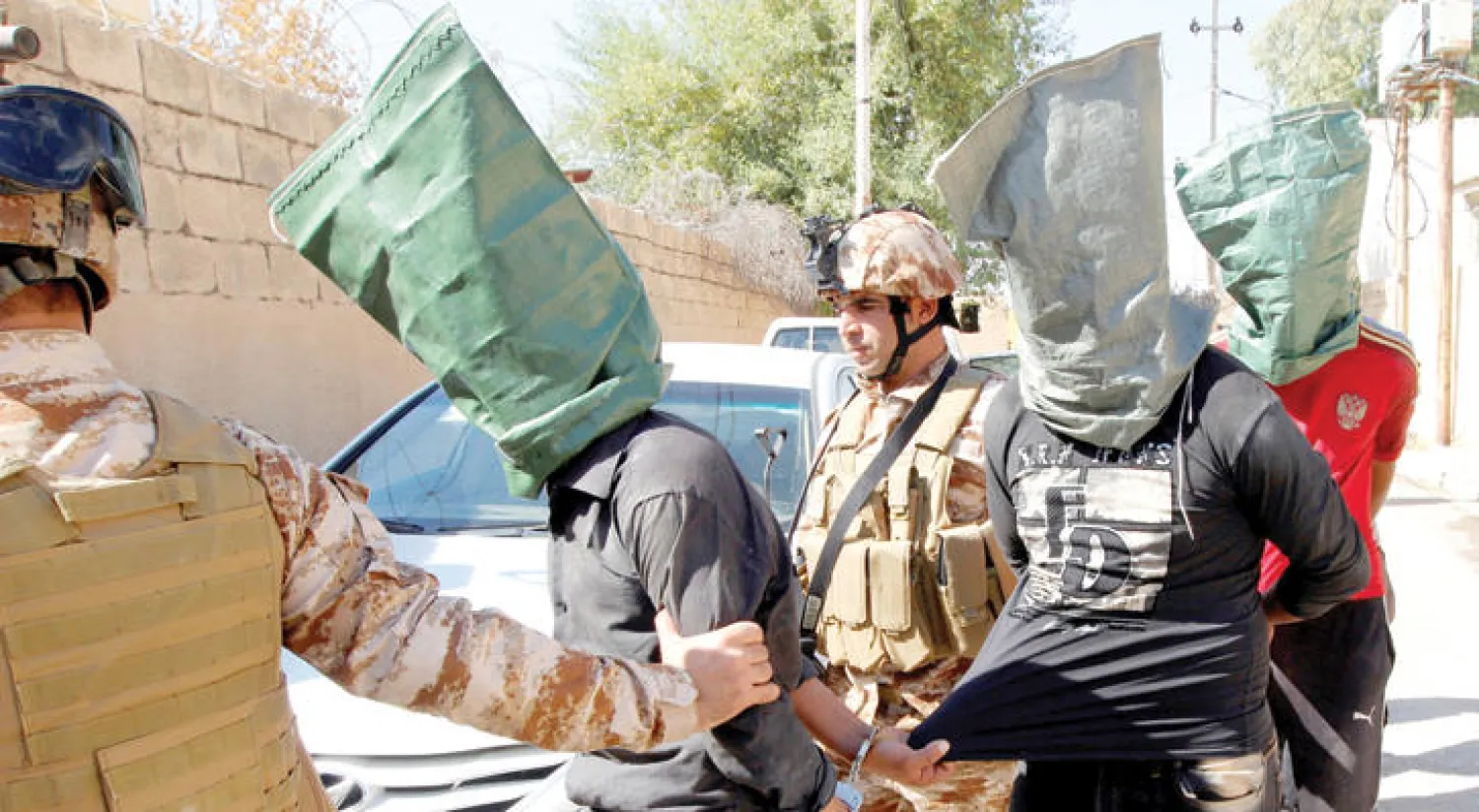 جنود يقتادون بعض أتباع «داعش» في أحد أحياء كركوك (رويترز)