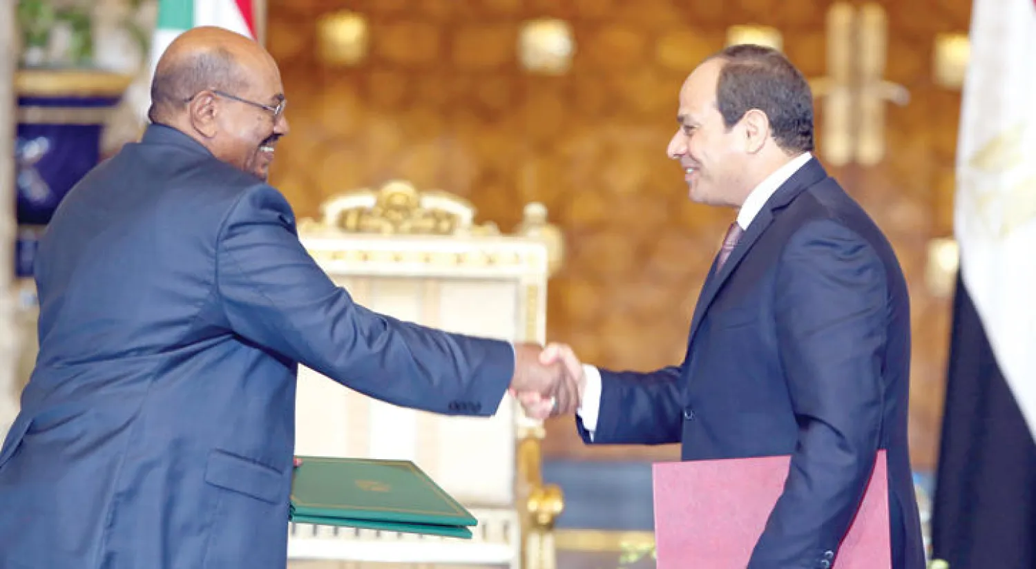الرئيس المصري عبد الفتاح السيسي مصافحا الرئيس السوداني عمر البشير بعد توقيع وثيقة الشراكة الاستراتيجية بين البلدين (إ.ب.أ)