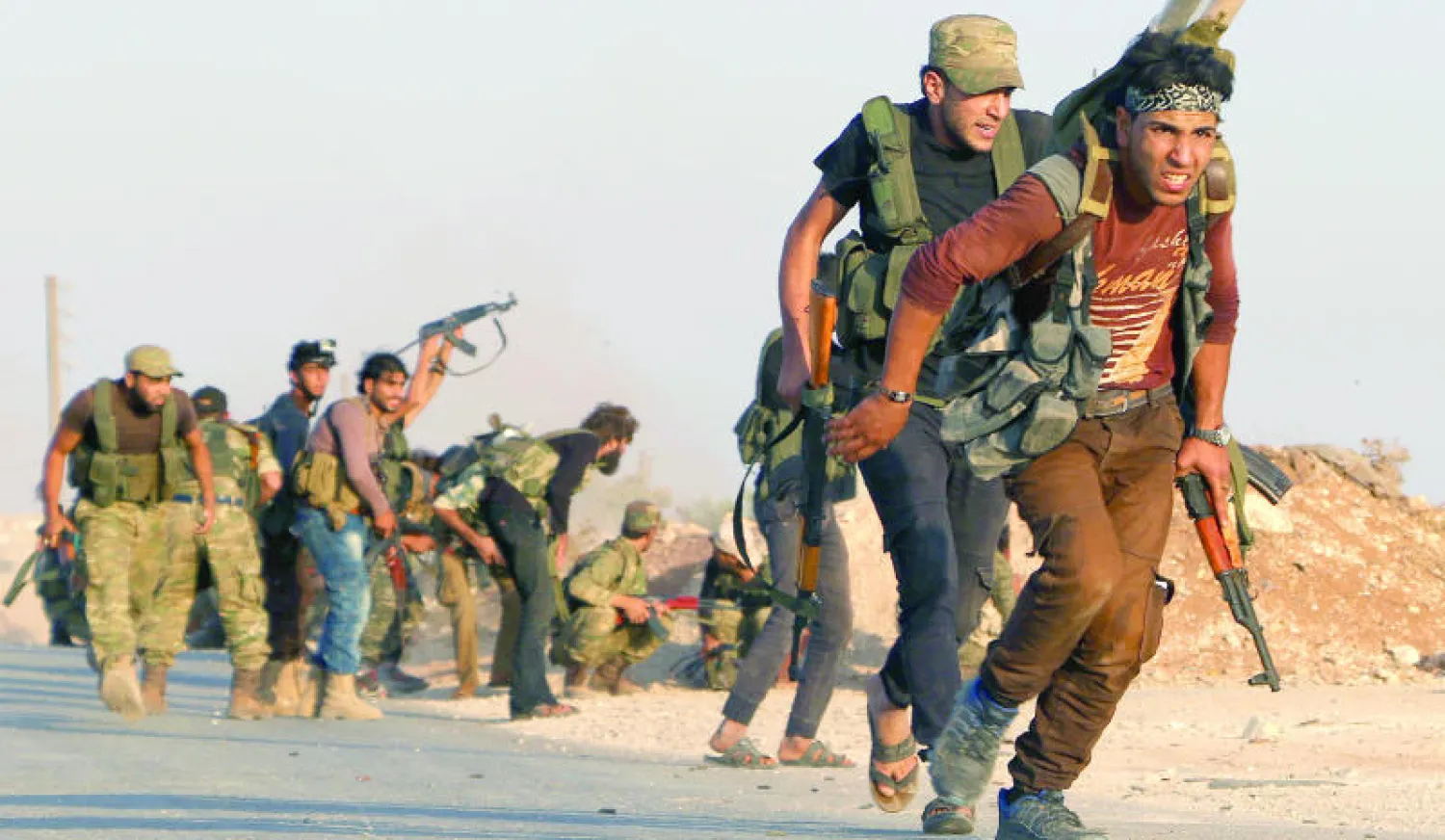 مقاتلون من الجيش السوري الحر في قرية يحمول بريف حلب ينطلقون إلى معركة ضد مقاتلي تنظيم داعش في مرج دابق أول من أمس (أ.ف.ب)