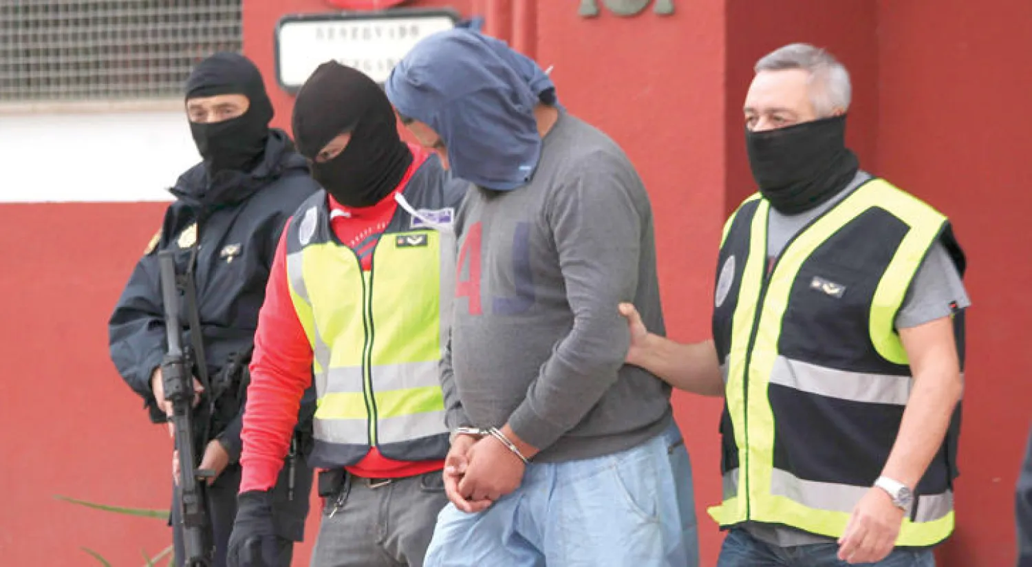 رجال  الأمن الإسباني يقتادون أحد المشتبه بهم في الانتماء لتنظيم «داعش» في مدينة سبتة أمس (إ.ب.أ)