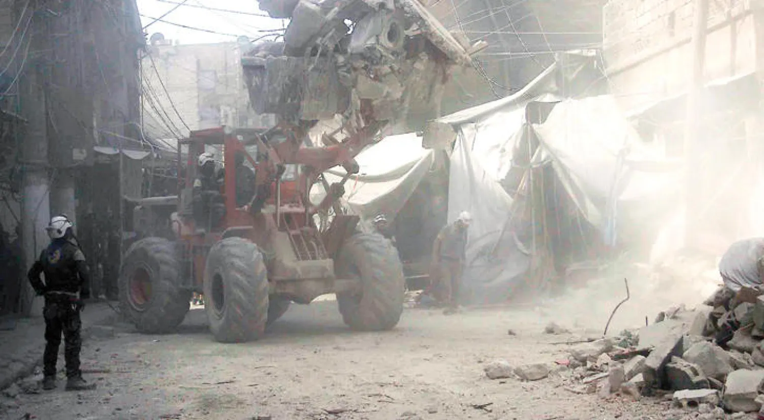 عناصر من قوات الدفاع المدني في شرق حلب يبحثون بين الأنقاض عن ناجين بعد انهيار الأبنية نتيجة قصف من الطيران الروسي الأسدي أول من أمس وأمس (إ ب)