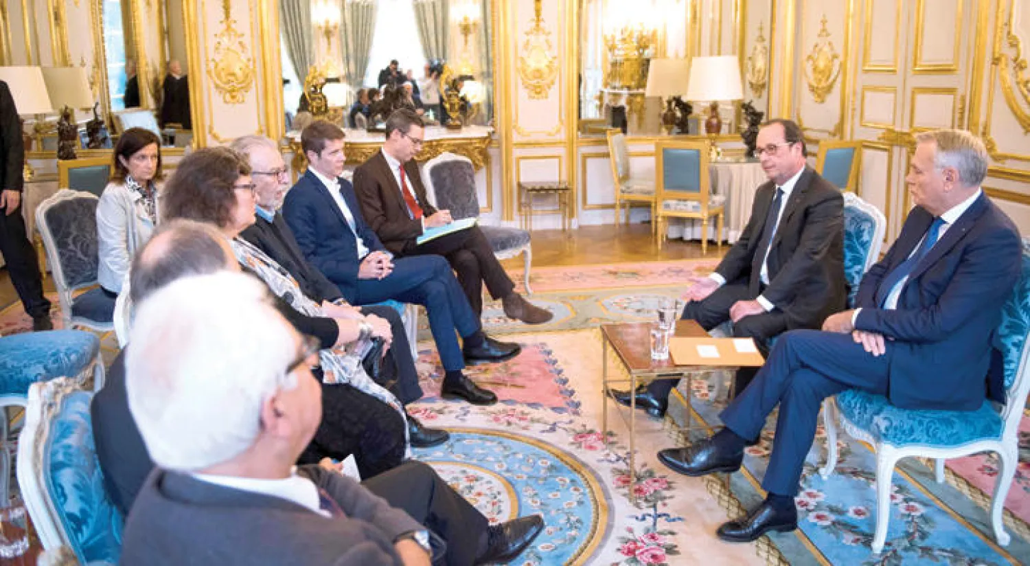 الرئيس الفرنسي فرنسوا هولاند مع وزير خارجيته جان مارك إيرولت خلال لقائهما ممثلين عن جمعيات سورية في باريس أول من أمس (أ.ف.ب)