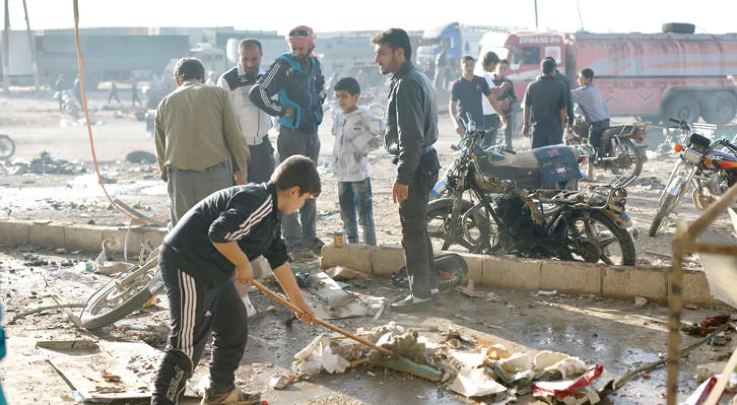 سوريون يعانيون آثار هجوم بسيارة مفخخة في مدينة أغراز القريبة من حلب أمس (غيتي)