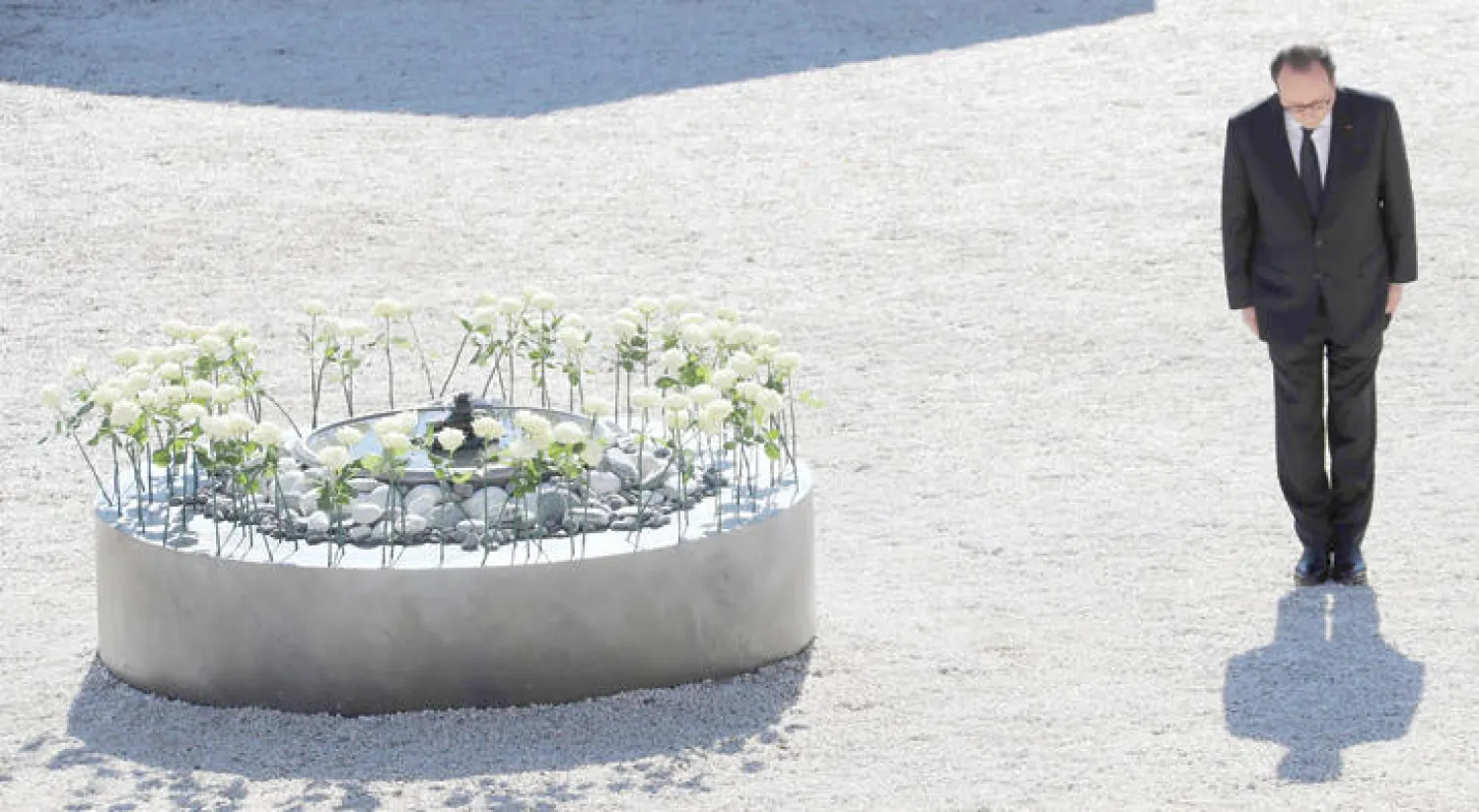 الرئيس الفرنسي فرنسوا هولاند يقف أمام إكليل من الزهور يمثل ضحايا مجزرة نيس أقيم على «متنزه الإنجليز} في مدينة نيس أمس (أ.ف.ب)