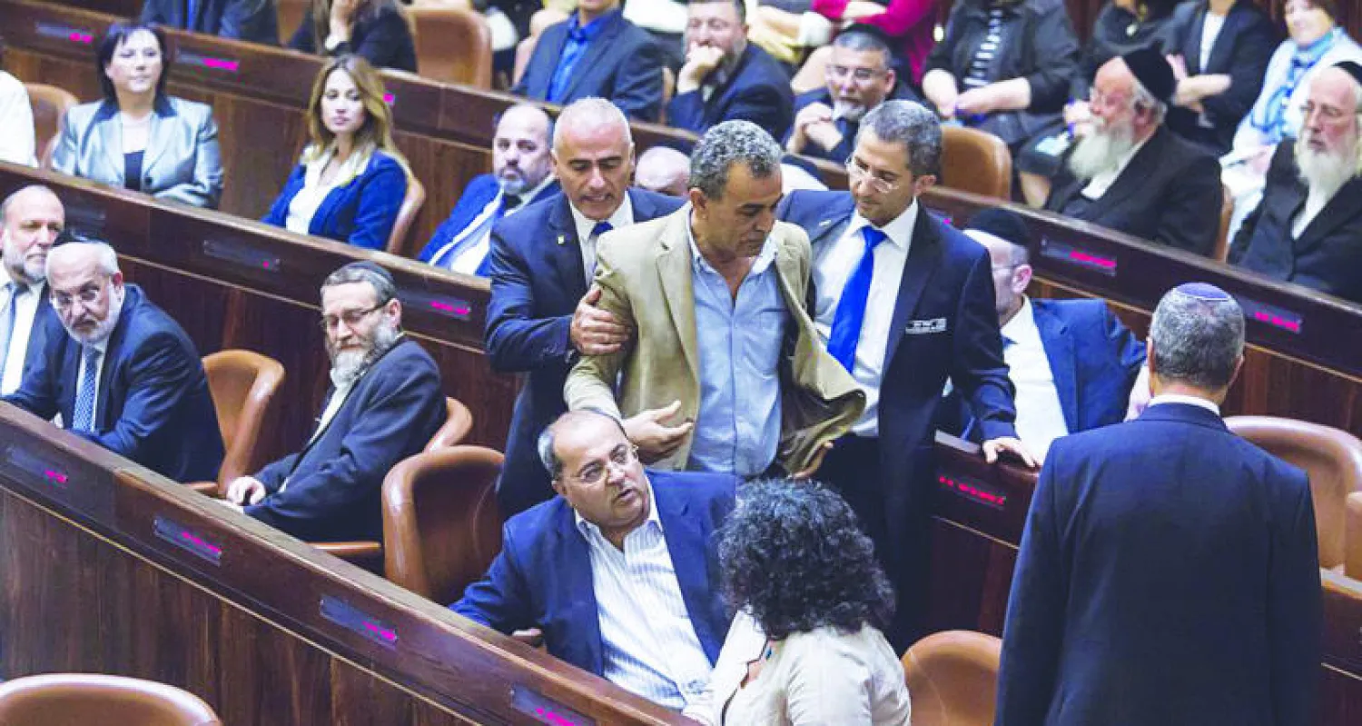 النائب العربي في البرلمان الإسرائيلي (الكنيست) الدكتور جمال زحالقة أثناء الطلب منه لمغادرة جلسة البرلمان إثر اعتراضه على كلمة لرئيس الوزراء بنيامين نتنياهو (أ.ف.ب)