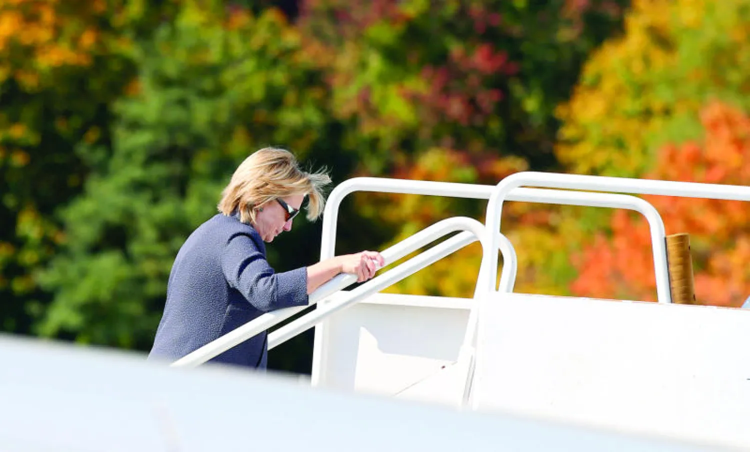 هيلاري كلينتون قبل إقلاعها من نيويورك أمس (رويترز)