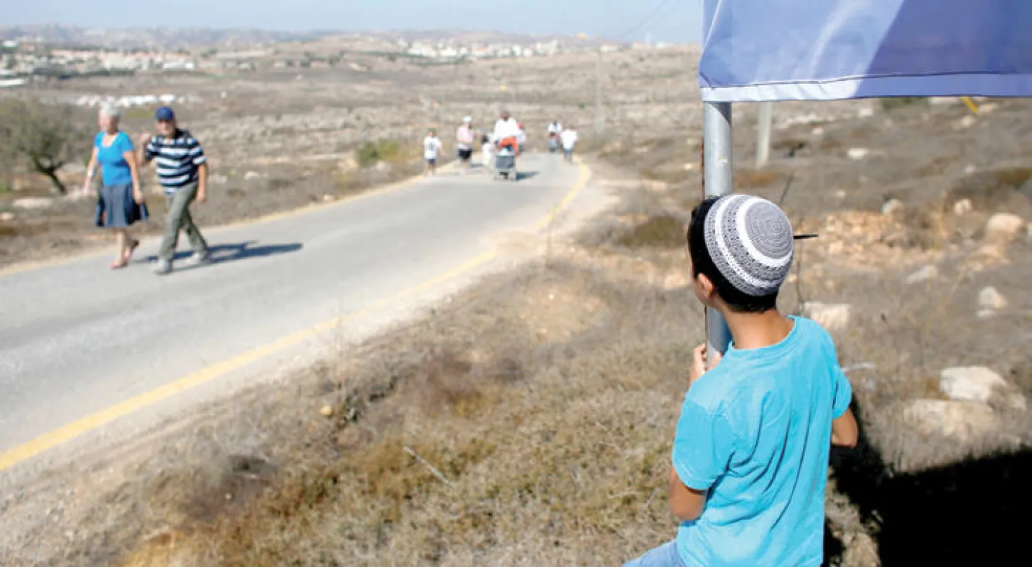 صبي يهودي يراقب إسرائيليين وهم يدخلون مستوطنة أمون التي بنيت بدون تصريح حكومي للتعبير عن تأييدهم للمستوطنة أمس  (رويترز)