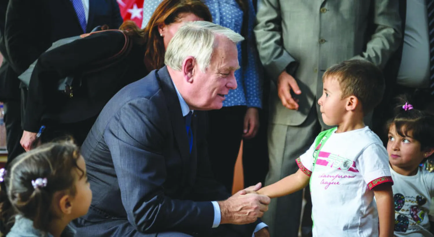 وزير الخارجية الفرنسي جان مارك أيرولت يتحدث إلى طفل سوري في مخيم كيليس قرب الحدود السورية وذلك خلال وجوده في مدينة غازي عنتاب التركية أول من أمس (أ.ف.ب)