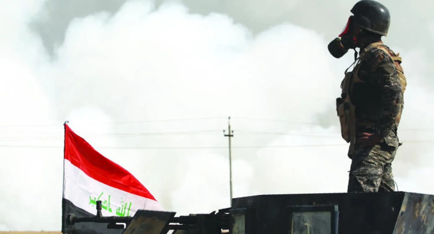 جندي عراقي يضع قناعا على وجهه بعد انبعاث الغازات السامة في الموصل (أ.ف.ب)