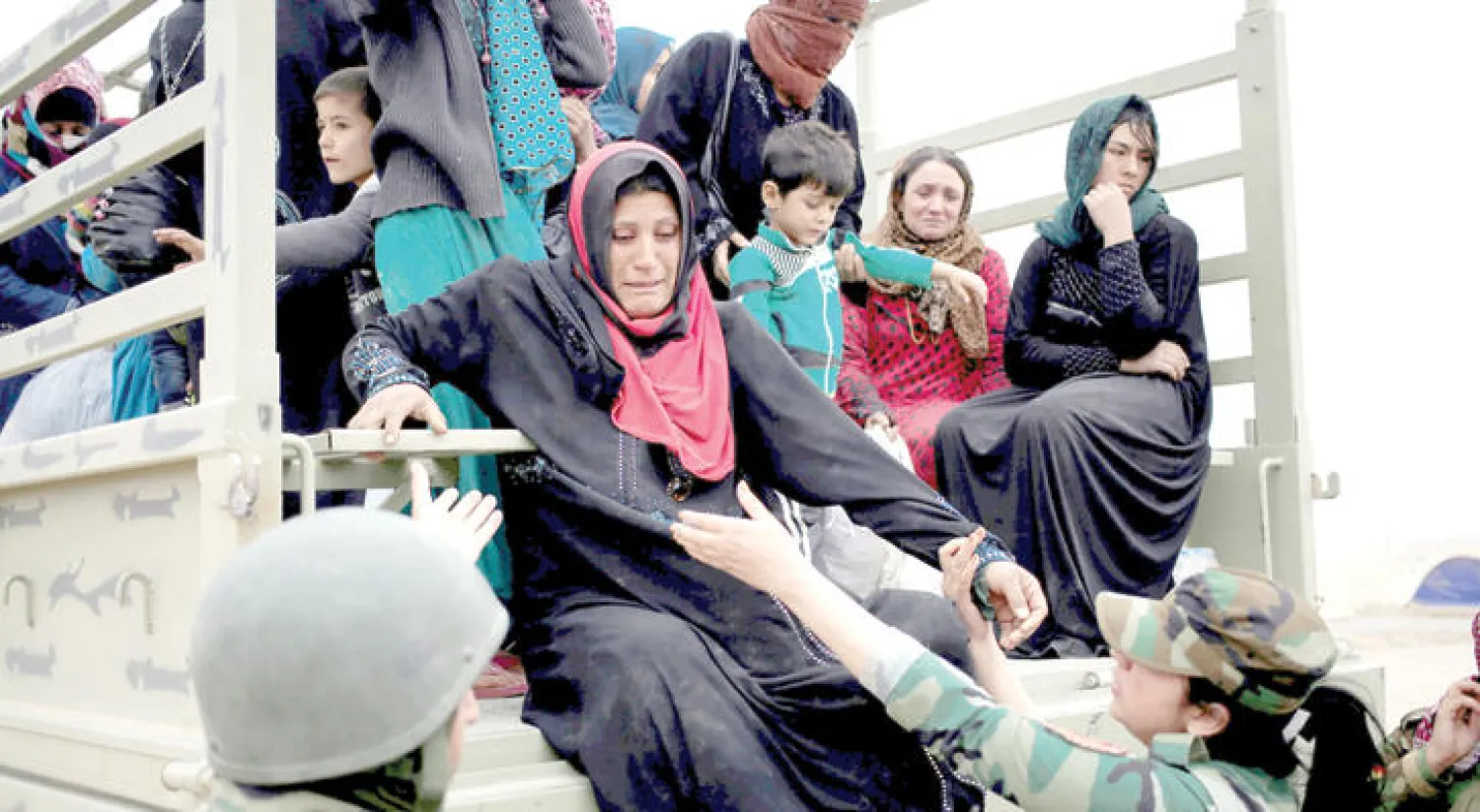 عناصر نسوية من البيشمركة يساعدن نازحات من قرى قريبة من الموصل وصلن أمس إلى مخيم للنازحين في منطقة الخازر شرق المدينة (رويترز)