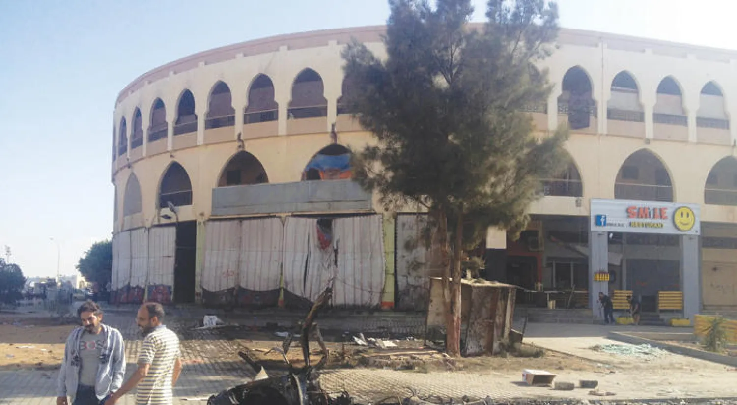 ليبيان يقفان بالقرب من مكان تفجير سيارة مفخخة في بنغازي أول من أمس (رويترز)