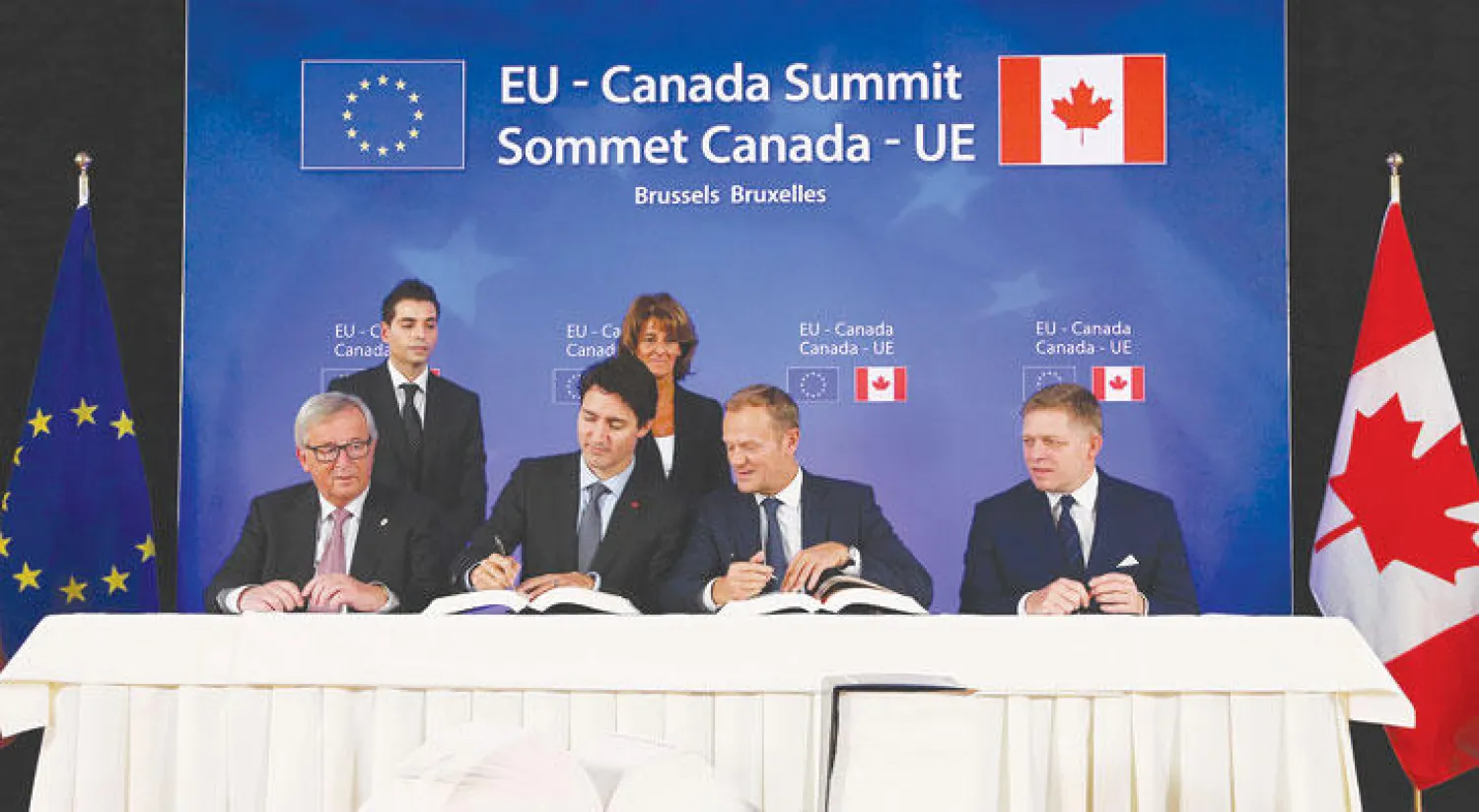مسؤولون في الاتحاد الأوروبي مع رئيس الوزراء الكندي أثناء التوقيع على اتفاقية التجارة الحرة بين الجانبين (.ف.ب)