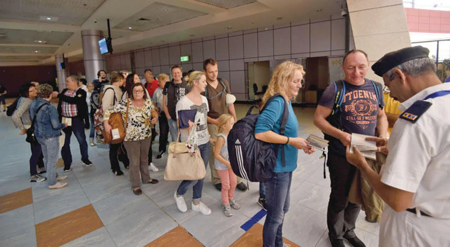 ركاب رحلة «إير جيرمانيا» الألمانية لدى وصولهم أمس إلى مطار شرم الشيخ الدولي في مصر بعد عام من شلل حركة السياحة عقب تفجير طائرة روسية فوق سيناء (أ.ف.ب)