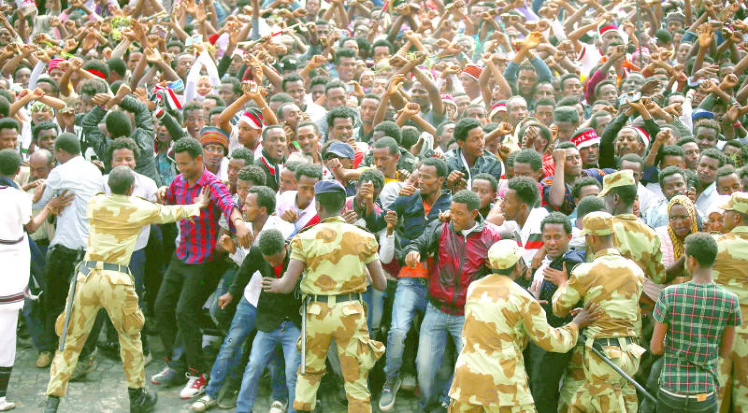 متظاهرون من قومية الأورومو يلوحون بعلامة قوميتهم أثناء مهرجان عيد الشكر (إريتشا) في مدينة بيشوفو الإثيوبية (رويترز)