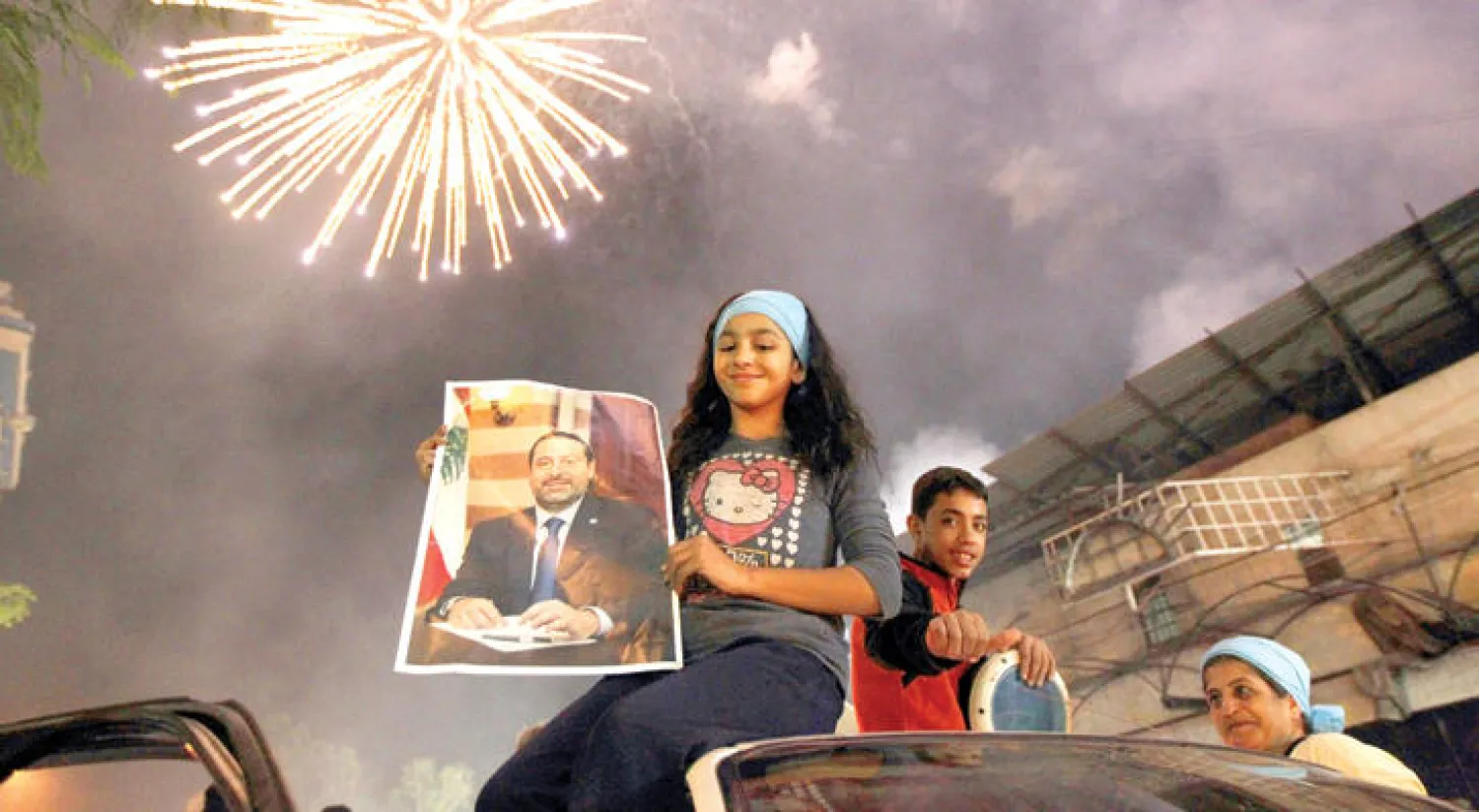 أطفال يحملون صورة للحريري لدى احتفالهم بإعلان تكليفه برئاسة الحكومة في بيروت (رويترز)