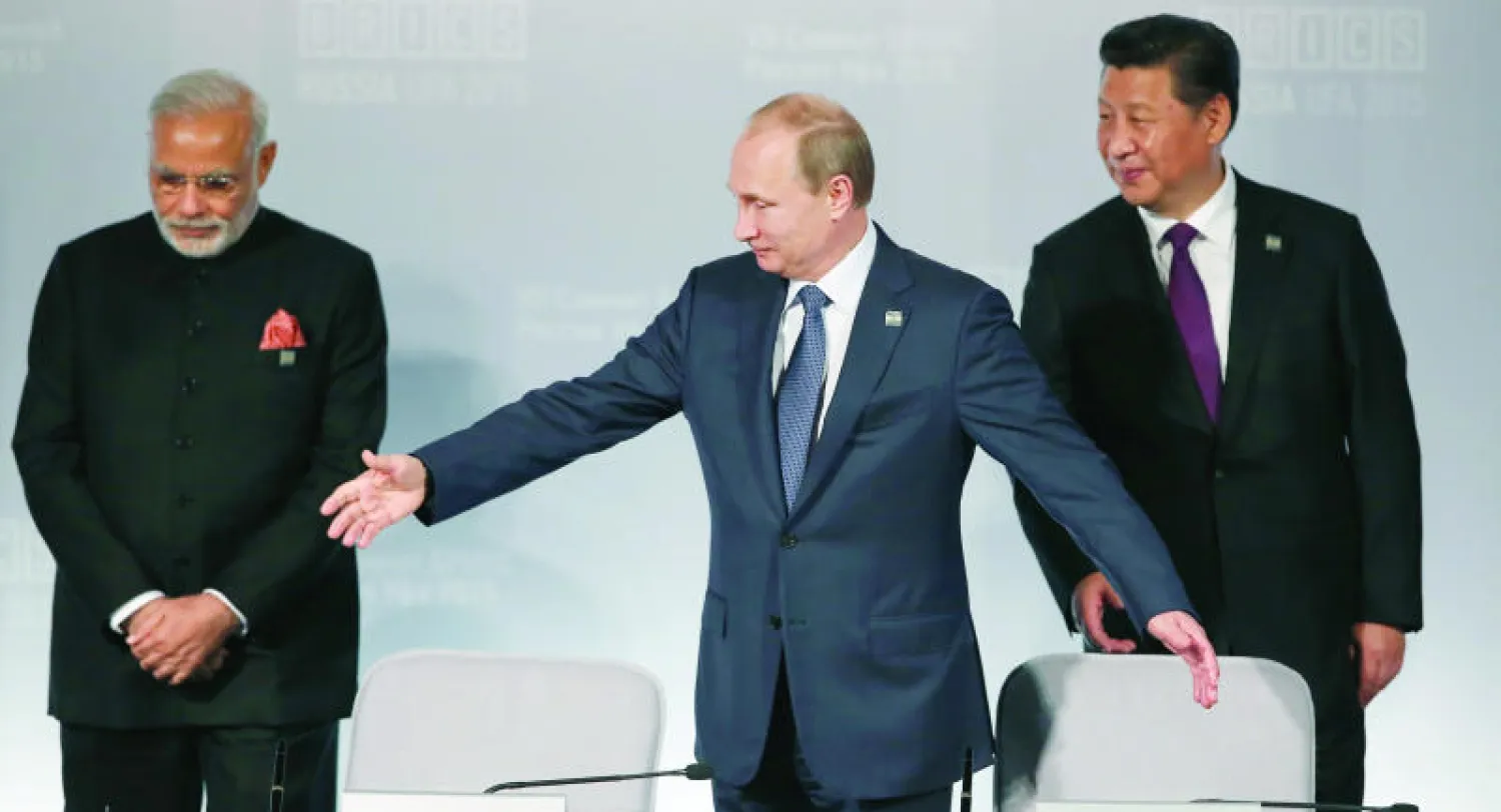 الرئيس الروسي فلاديمير بوتين ولعبة التوازن بين الرئيس الصيني ورئيس وزراء الهند ناريندرا مودي خلال قمة بريكس التي استضافتها الهند (أ.ب)