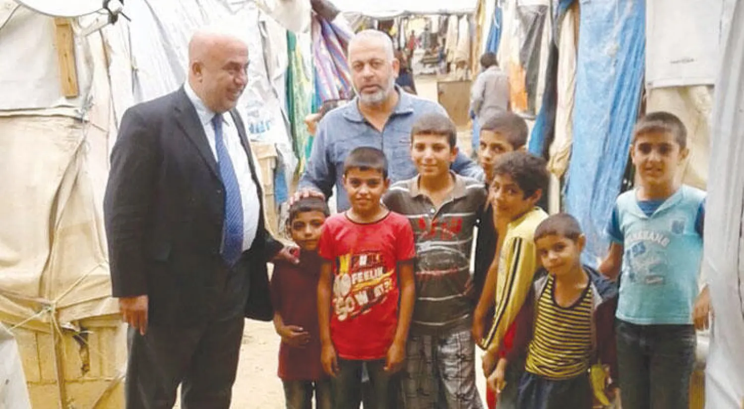 أطفال أثناء تقديم المساعدات للعائلات النازحة في المخيم الواقع ببلدة الريحانية في عكار شمال لبنان («الشرق الأوسط»)