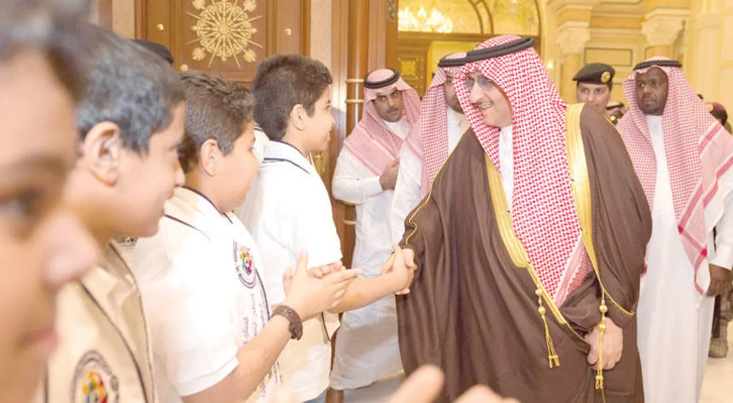 الأمير محمد بن نايف ولي العهد السعودي  مصافحًا عددًا من الأطفال الذين حرصوا على السلام عليه لدى رعايته الملتقى