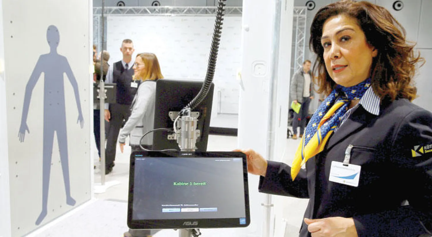 موظفة في شركة خاصة للأمن تعرض نظاما للمسح الشامل للمسافرين في مطار كولون الألماني أول من أمس (رويترز)