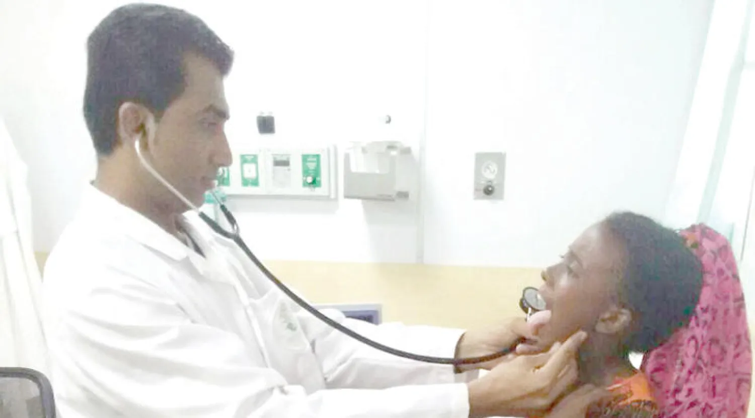 طبيب يفحص طفلة يمنية في عيادات مركز الملك سلمان بمخيم اللاجئين اليمنيين في محافظة أبخ بجيبوتي («الشرق الأوسط»)