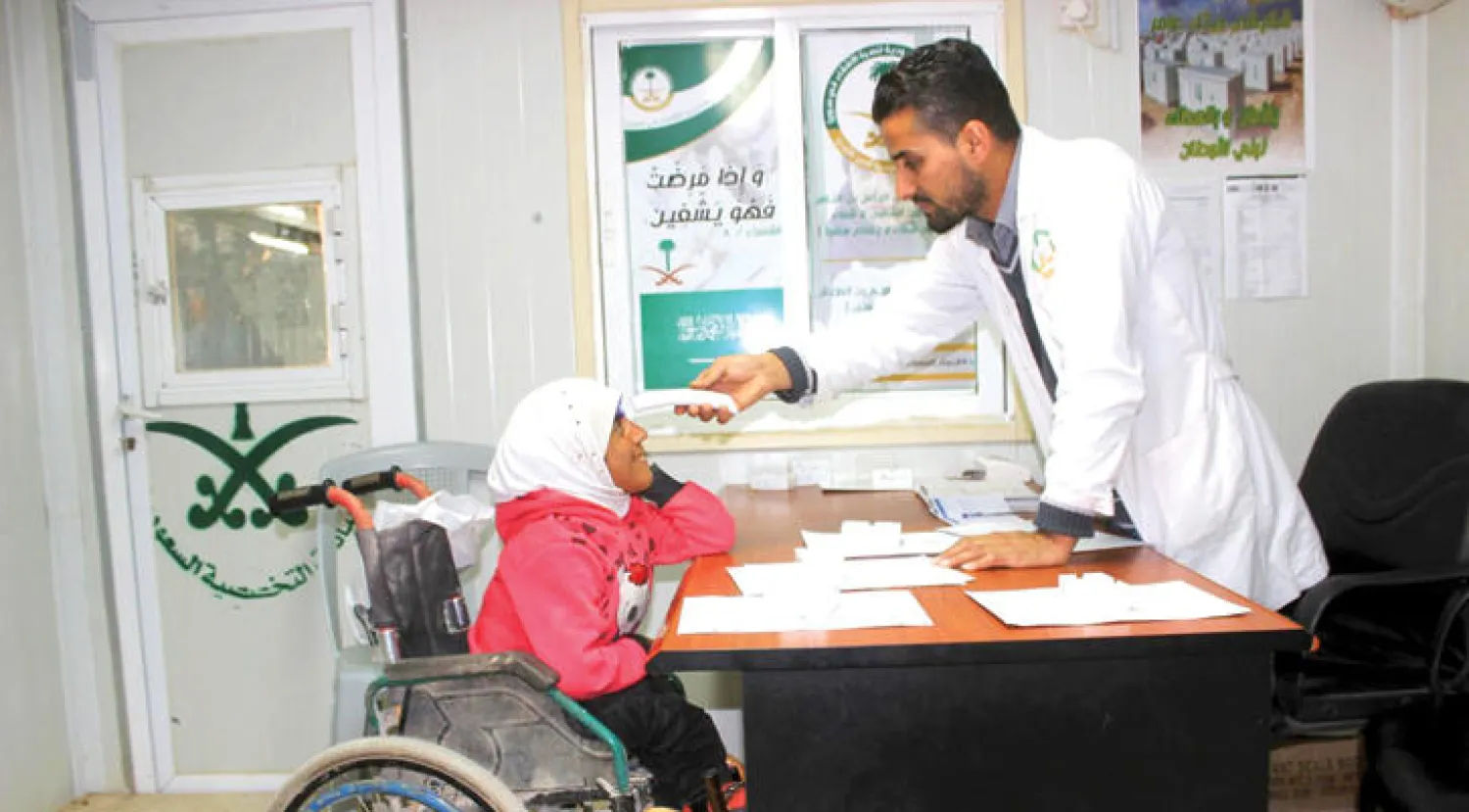 أحد الأطباء في العيادات التخصصية السعودية يجري الفحوص لإحدى اللاجئات السوريات في مخيم الزعتري بالأردن .. و أخر يجري فحصاً لطفل سوري في المخيم المذكور (واس)