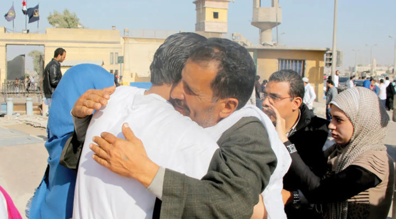 مصري يحتضن قريبه السجين بعد أن أفرج عنه من سجن طرة ضمن السجناء الذين أفرج عنهم بقرار عفو من الرئيس السيسي (إ. ب. أ)