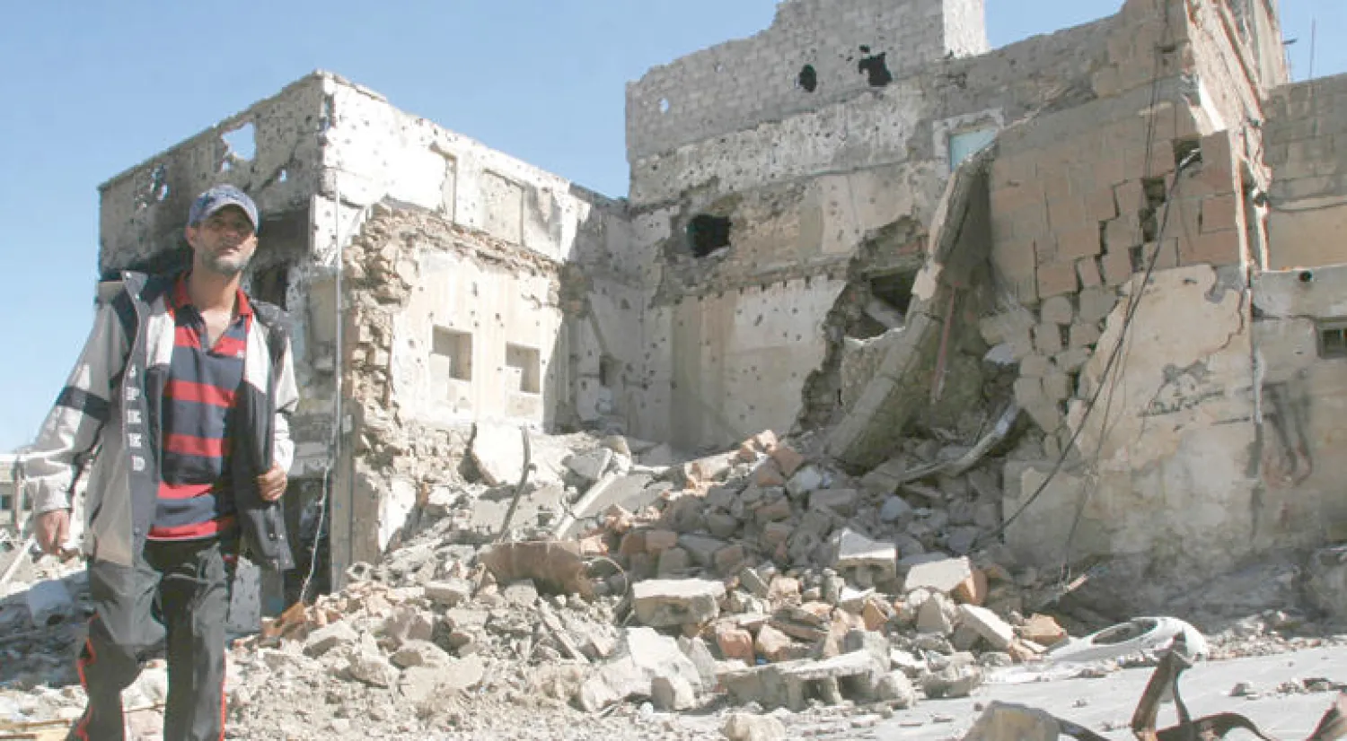 يمني يسير جوار دمار خلفه قصف الميليشيات الانقلابية في تعز (رويترز)