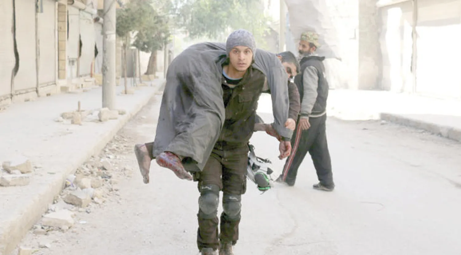 متطوعون من الانقاذ المدني يسعفون جريحاً إثر غارات للنظام على حلب (أ.ف.ب)