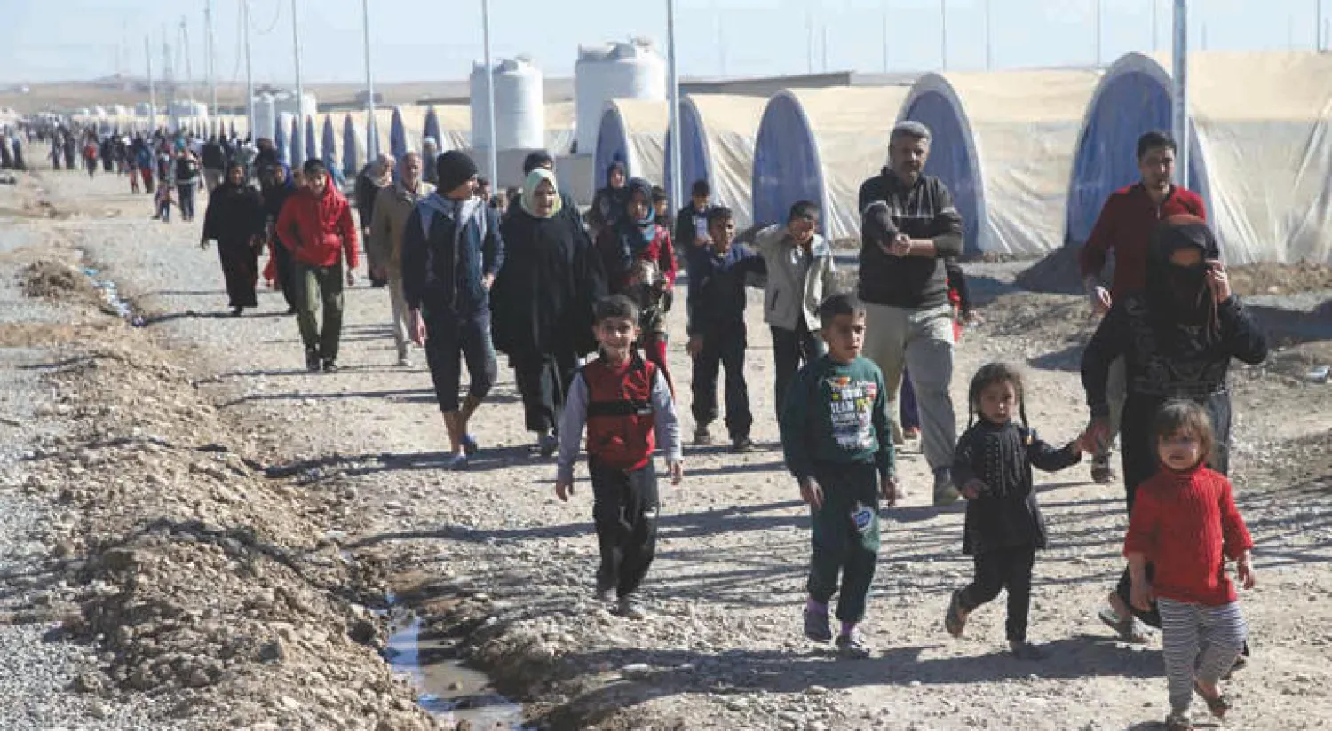 عراقيون هاربون من مناطق القتال الدائر بين «داعش» والقوات العراقية في مخيم خزر المقام شرق الموصل (أ.ب)