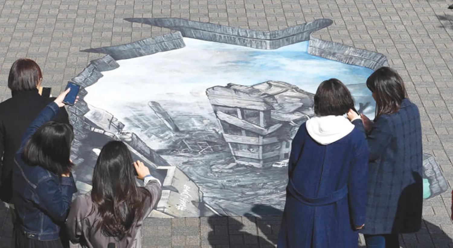 لوحة ثلاثية الأبعاد على أرضية جامعة ميجي في طوكيو عرضها مكتب منظمة العفو الدولية لتعريف اليابانيين بمأساة الحرب في سوريا (أ.ف.ب)