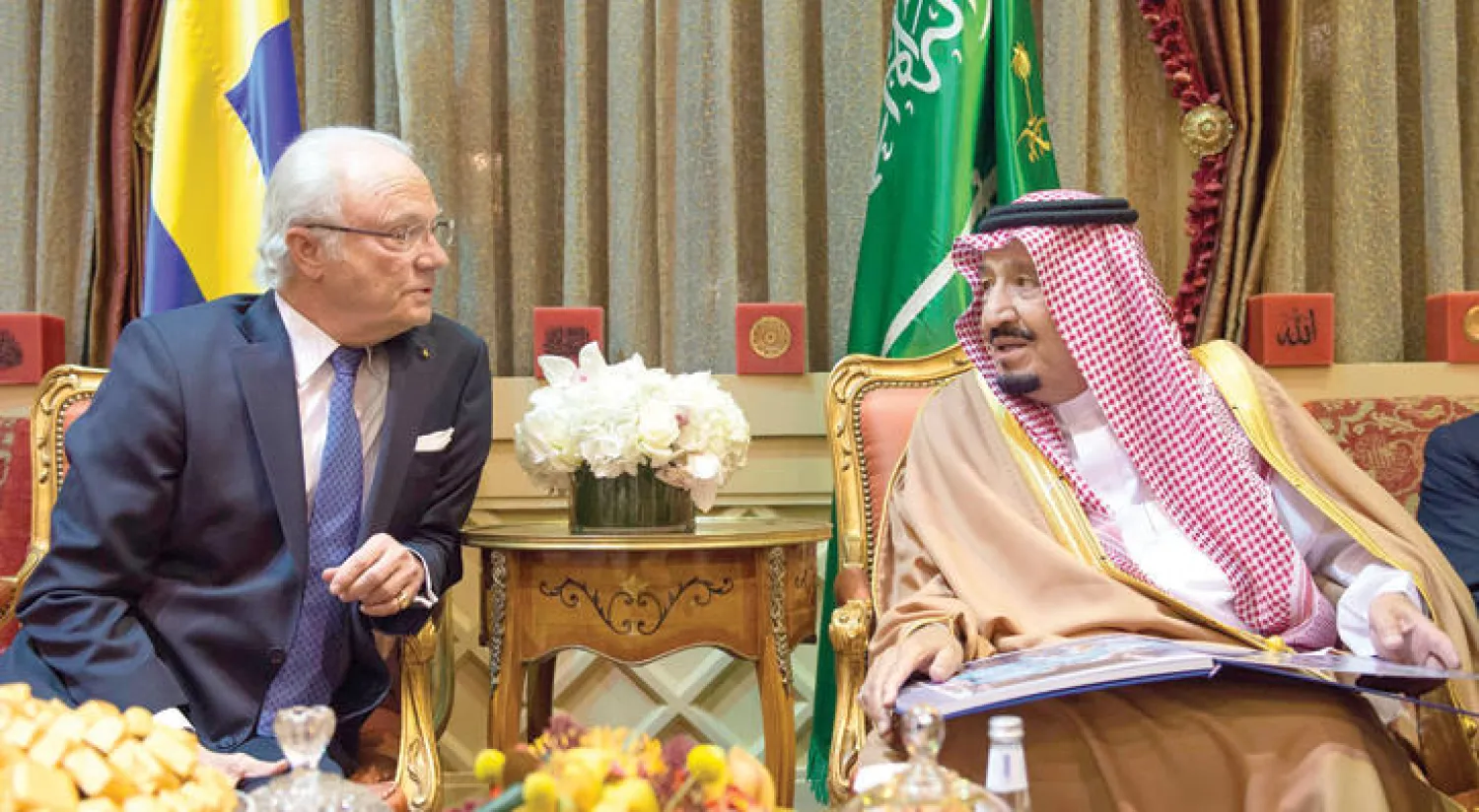 الملك سلمان بن عبد العزيز في حديث جانبي مع العاهل السويدي خلال اطلاعه على أحد إصدارات الحركة الكشفية العالمية (واس)