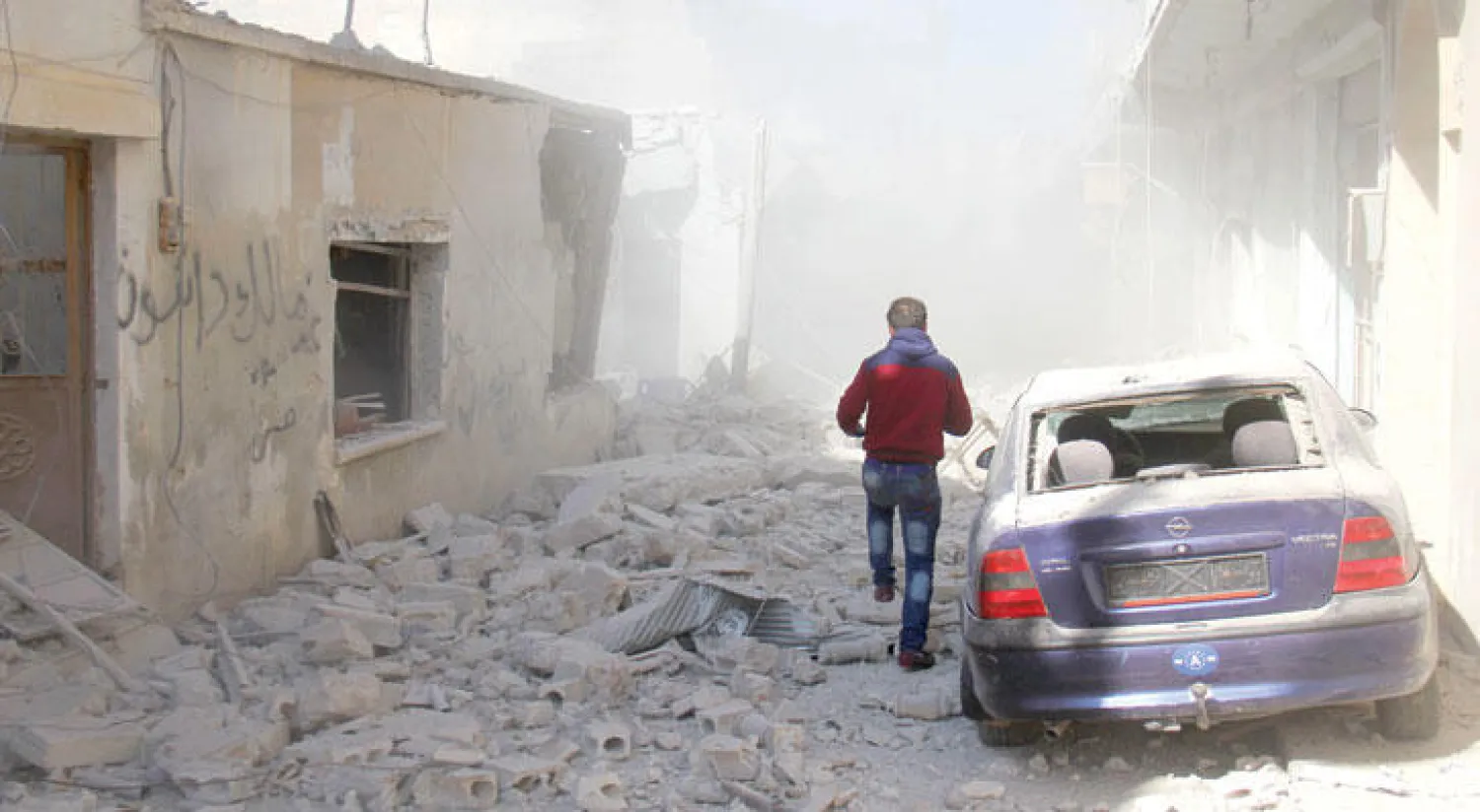 شاب من بلدة بنش بريف إدلب شمال سوريا يبحث عن ملاذ وسط أبنية مدمرة استهدفها الطيران الروسي الثلاثاء الماضي(أ.ف.ب)