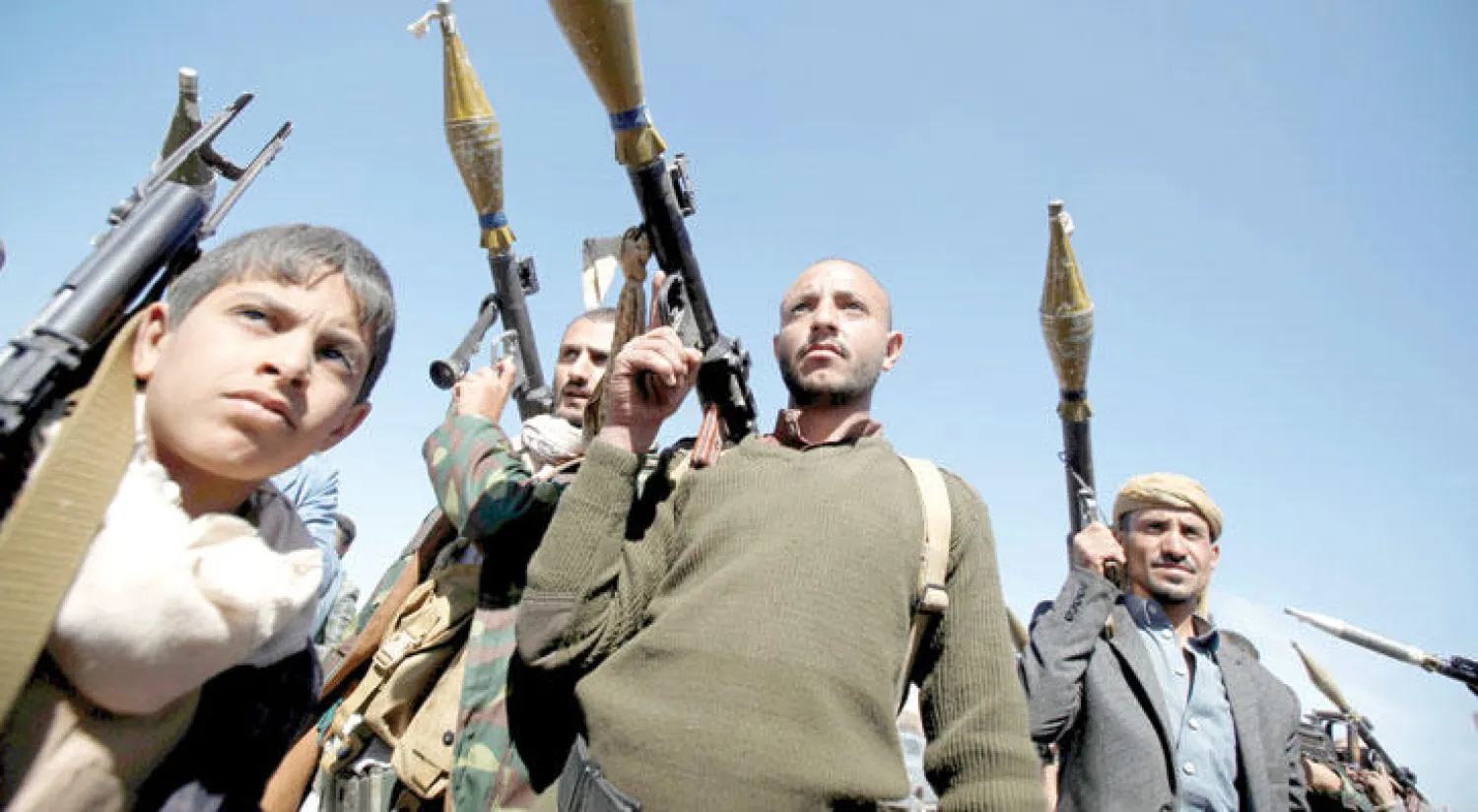 قوات موالية لانقلابيي اليمن خلال استعراض بالأسلحة في صنعاء أمس.. ويبدو طفل مسلح بينهم (رويترز)