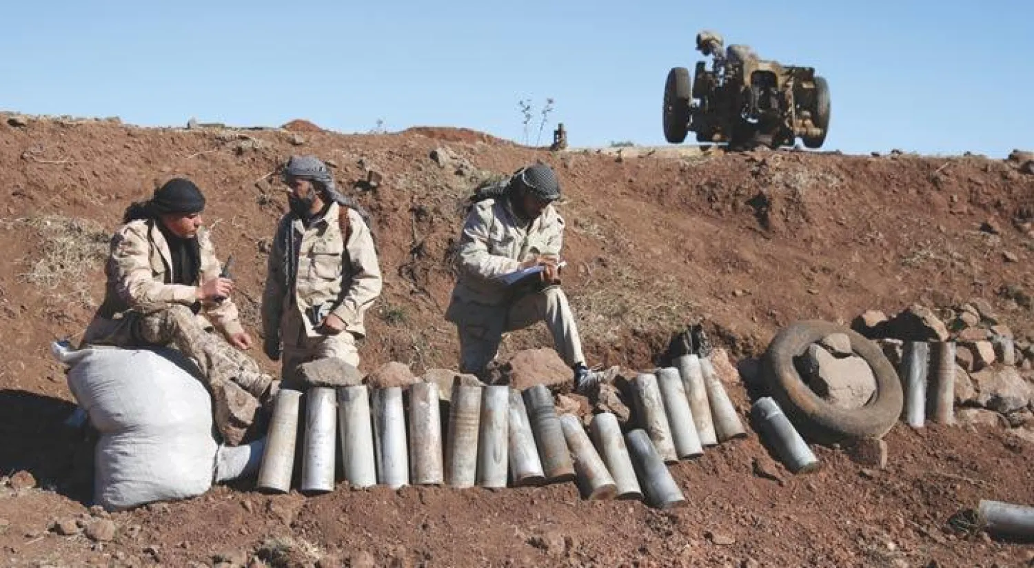 مقاتلون من الفصائل المعارضة للأسد قرب صواريخ فارغة في قرية جباتا الخشب بمحافظة القنيطرة جنوب غربي سوريا أول من أمس (رويترز)