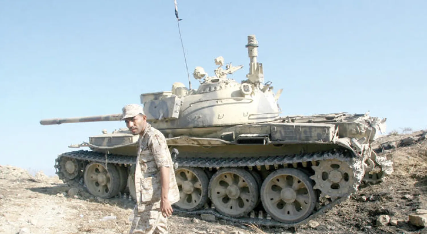 مقاتل من الجيش اليمني يسير قرب دبابة في إحدى جبهات بتعز (رويترز)