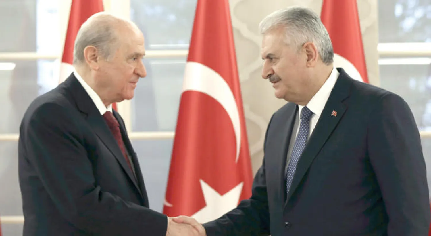 رئيس الوزراء التركي بن علي يلدريم (يمين) مع رئيس حزب الحركة القومية دولت بهشلي (أ.ب)