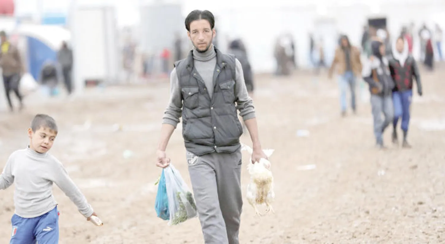 نازح عراقي فر من المعارك الدائرة حول الموصل يسير في مخيم الخنازير للنازحين المقام بين الموصل وأربيل (أ.ف.ب)