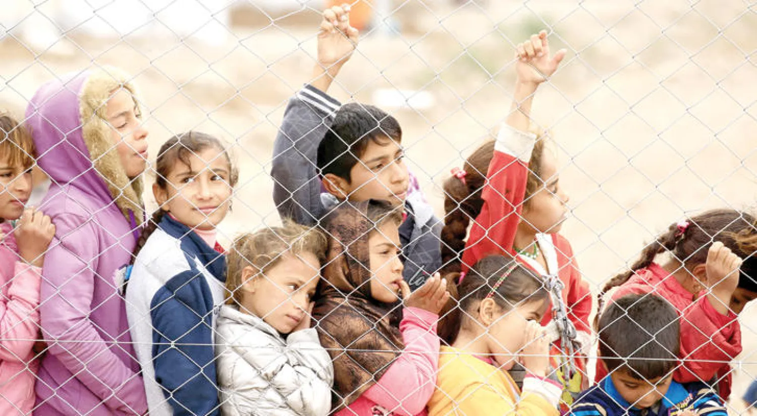 أطفال عراقيون نازحون من الموصل هرباً من {داعش} يقفون في مخيم ديبكة تمهيداَ لنقلهم إلى أربيل (رويترز)