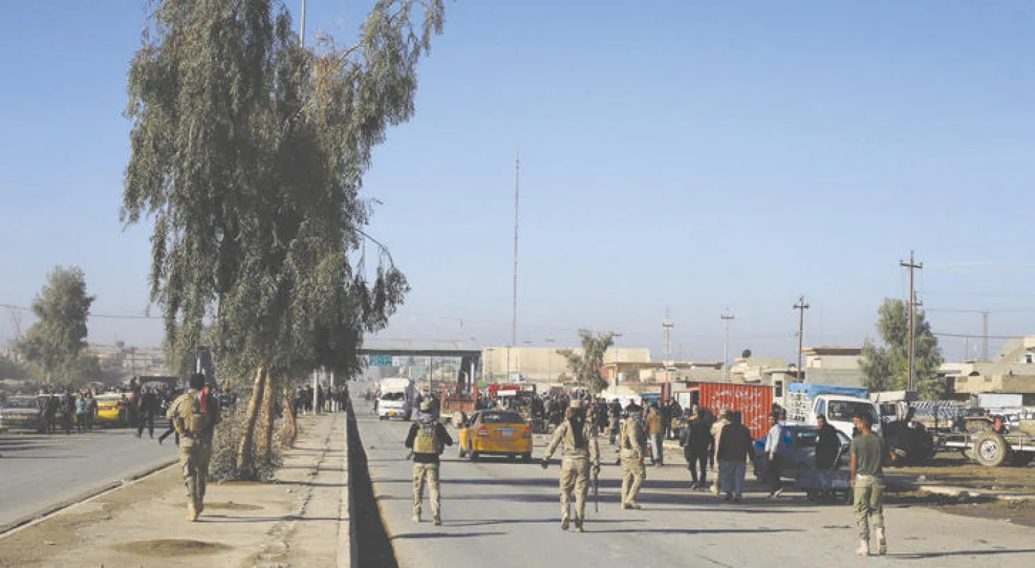 عدد من رجال الأمن العراقيين في أحد شوارع ضاحية كوجيالي بالموصل (رويترز)